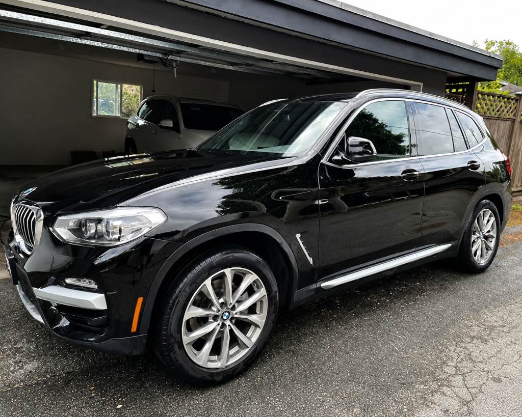 Freshly detailed SUV in front of a garage